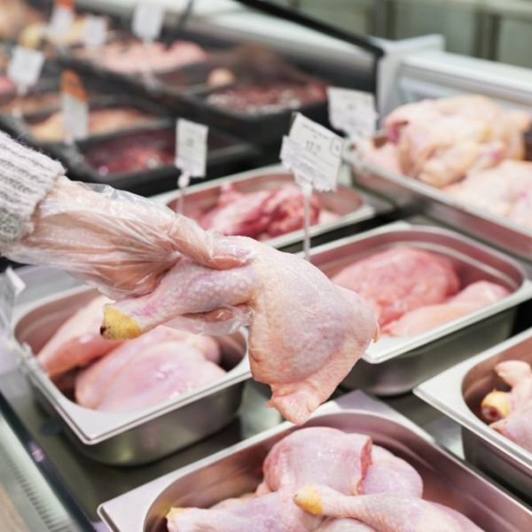close-up hand woman shopping for chicken meat in a store